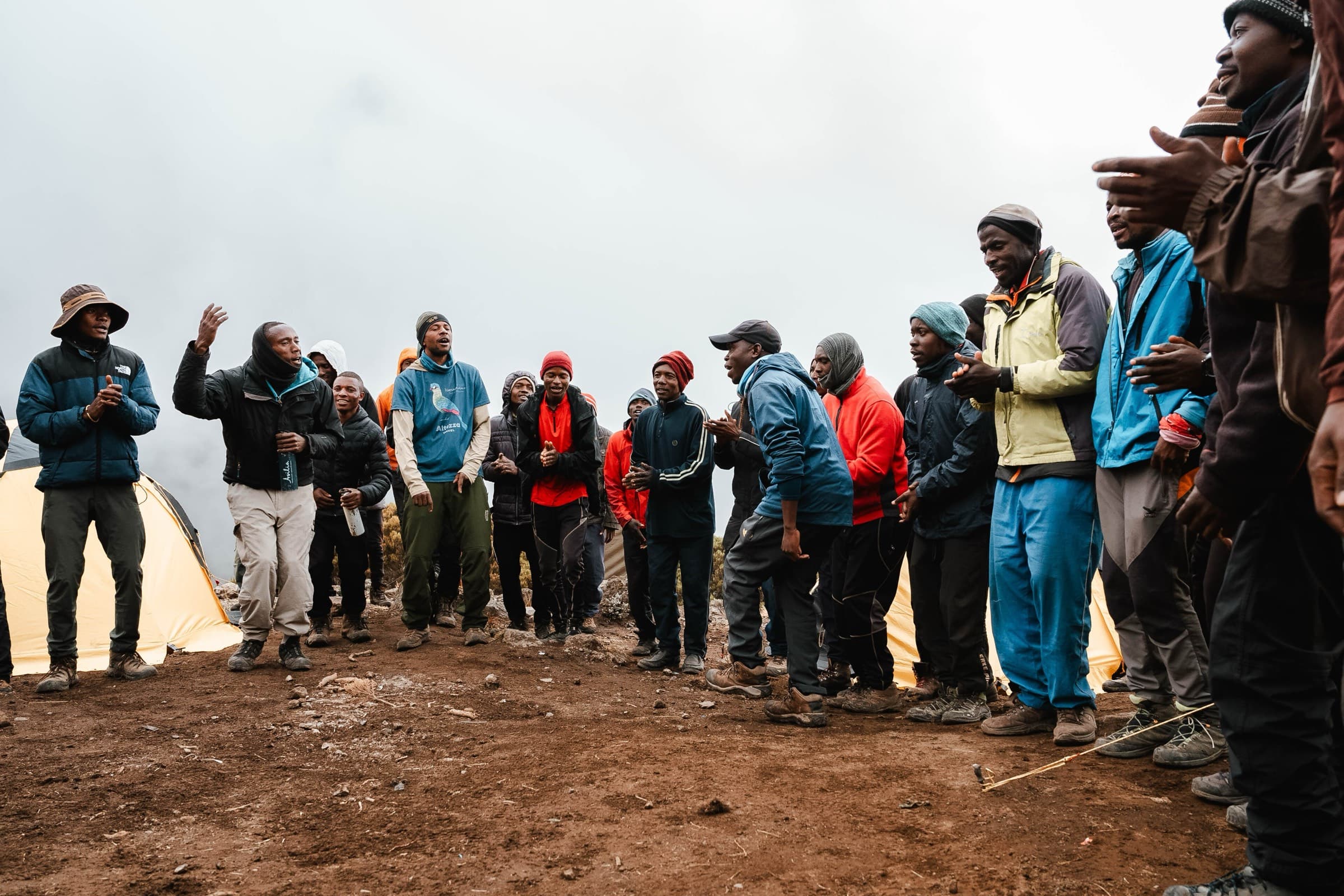 Mountain crew gathered in a circle at a high camp on Kilimanjaro